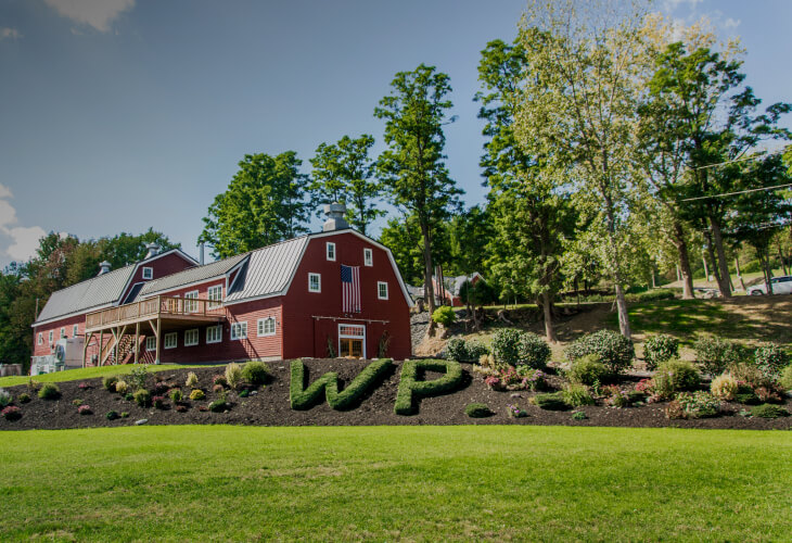 Red barn at WhistlePig Farm surrounded by green hills
